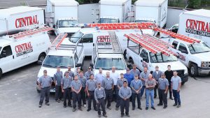 Central Roofing employee team standing in front of company trucks